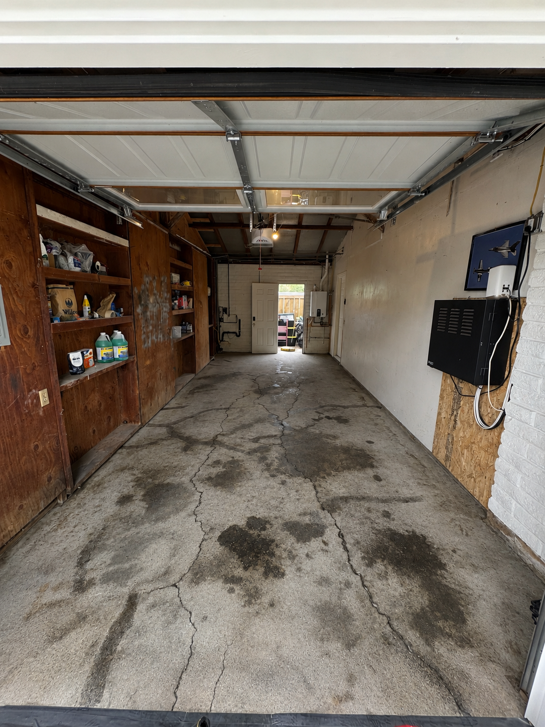 Bare, cracked concrete garage floor before diamond grinding